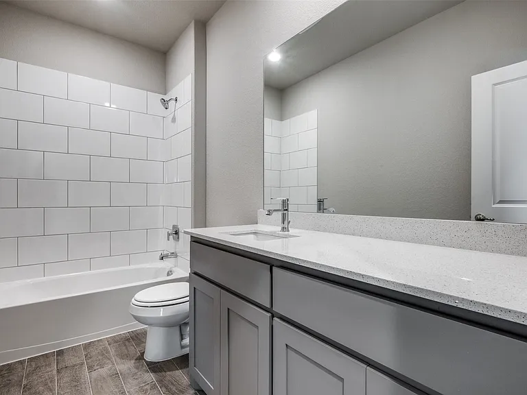 2nd Full bathroom with oversized vanity, toilet, and tiled shower / bath combo