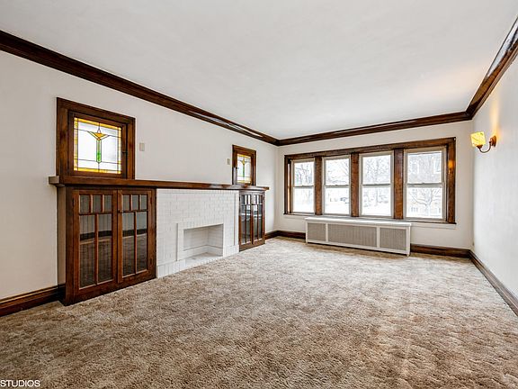 Living Room features a faux fireplace, built in cabinets, and stained glass windows