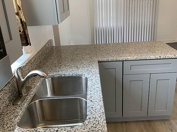 New kitchen with granite countertop and under mounted stainless sink and new cabinets and vinyl flooring and new light fixtures