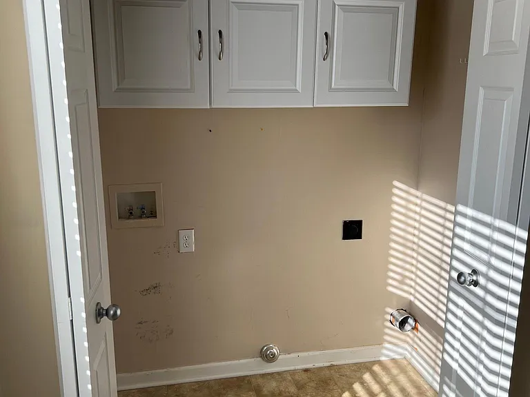 Laundry closet with built in cabinets.