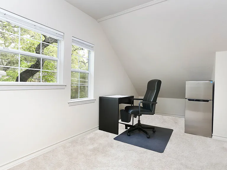 Small desk area upstairs with small fridge.