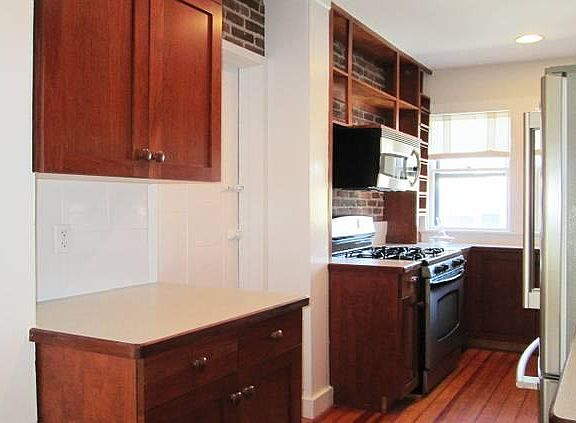 Lovely kitchen with cherry cabinets and exposed brick