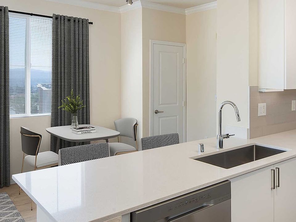 Renovated Package II kitchen and dining area featuring white cabinetry, white quartz countertops, stainless steel appliances, and hard surface flooring