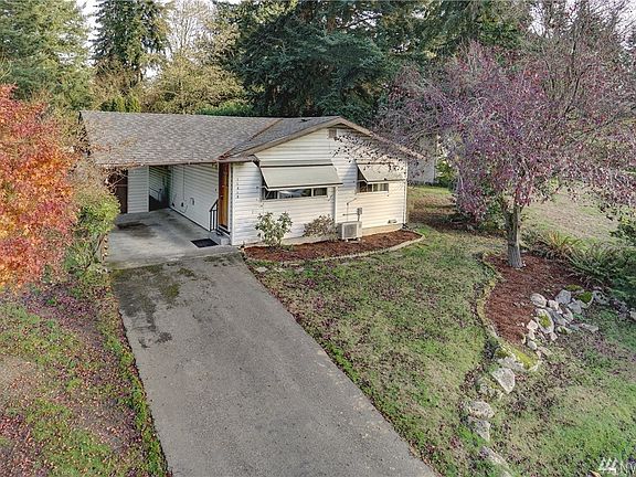 The home is surrounded by colorful mature landscaping.