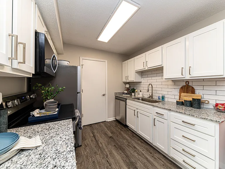 Kitchen with granite counters, modern cabinetry, & hardwood-style flooring