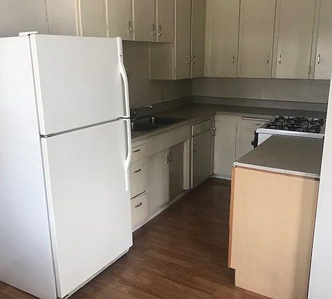 Kitchen - Gas range, lots of cabinet storage, wood floors