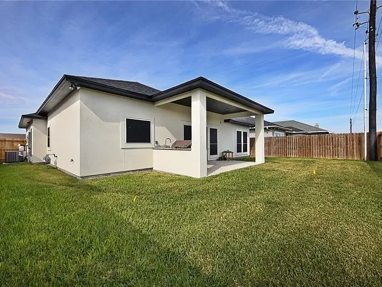 Rear exterior view highlighting the covered patio and outdoor living space.