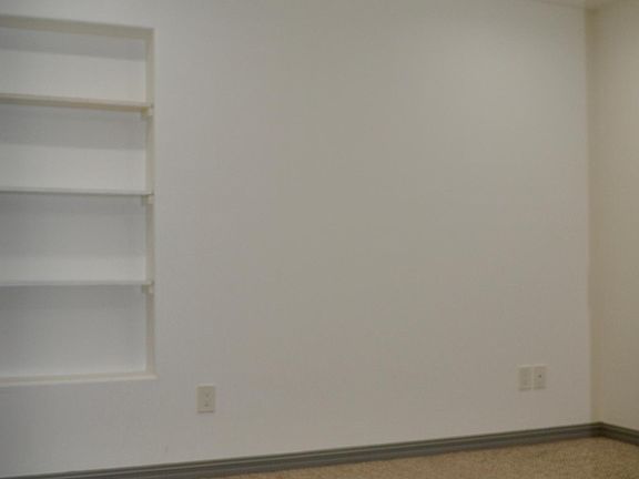 Bedroom 1 with built-in shelving. Recessed LED lighting.