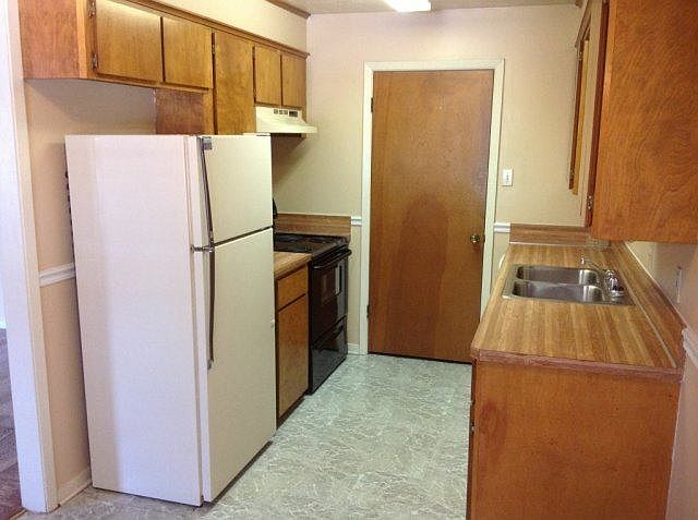 Galley kitchen includes lots of cabinet space, refrigerator,