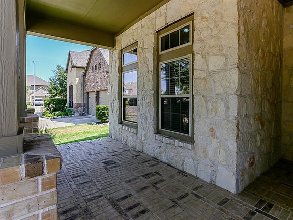 Beautiful extended covered front porch on a quiet street located in the award winning community of Lakes of Bella Terra!  Beautiful stone with brick paver give warmth along with coziness to a unique and rare feature of the front covered porch.   Great for a swing or outdoor seating.