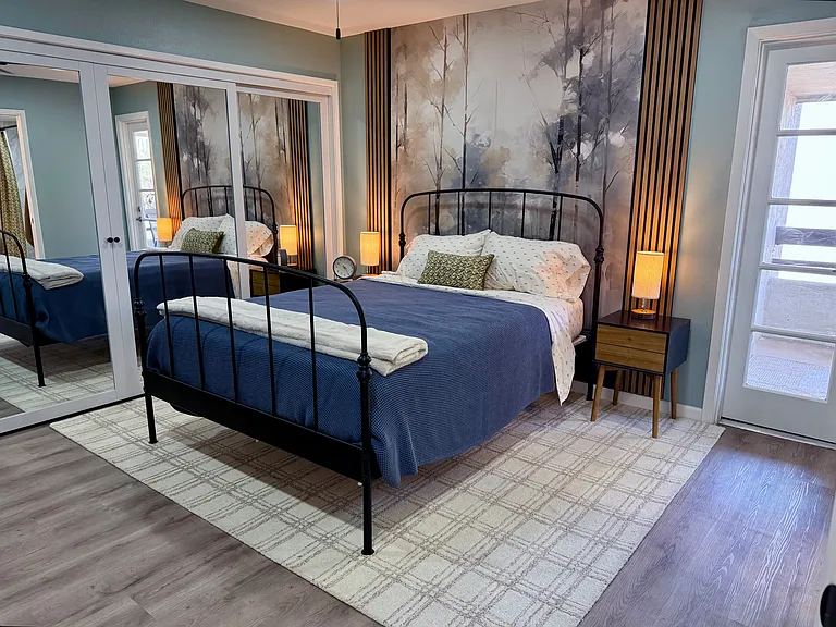 Split master/2nd bedroom offers comfortable queen bed, private balcony & en-suite bathroom shared via hallway for guests.