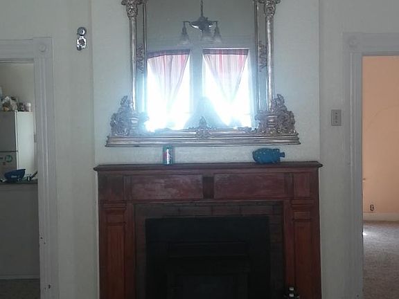 The fireplace and mantle in the dining room. Kitchen doorway