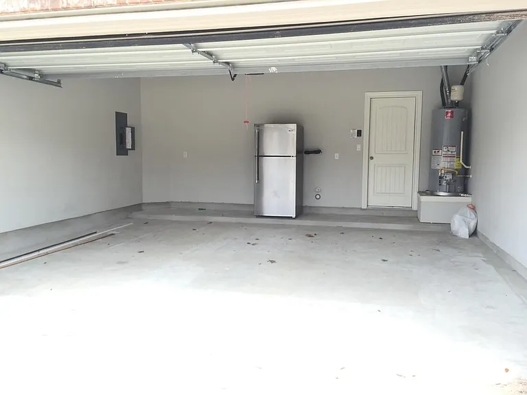Two car garage with an additional stainless steel refrigerator