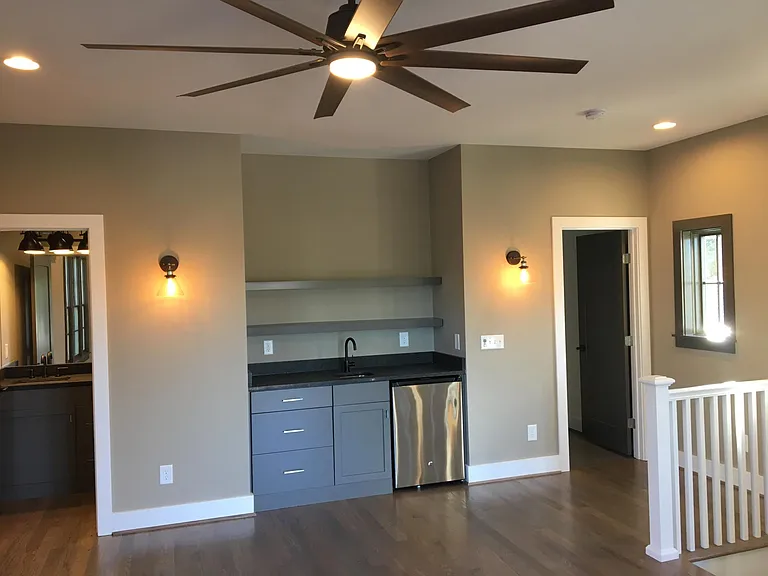 Upstairs common area has a powder room, den space, wet bar with sink and small fridge plus a storage closet. This opens up to the rooftop deck.