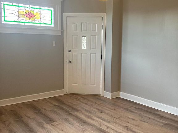 Living room with beautiful stained glass window. Hardwood floors.