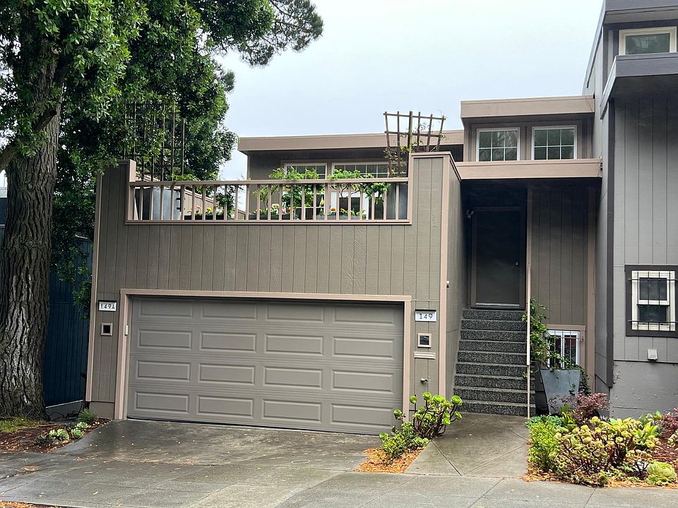 Tree-lined street with large deck above garage