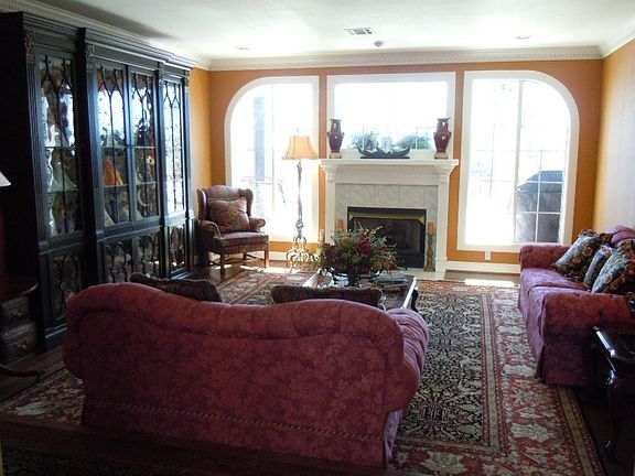 Formal Living with fireplace & large window overlooking deck & pool area