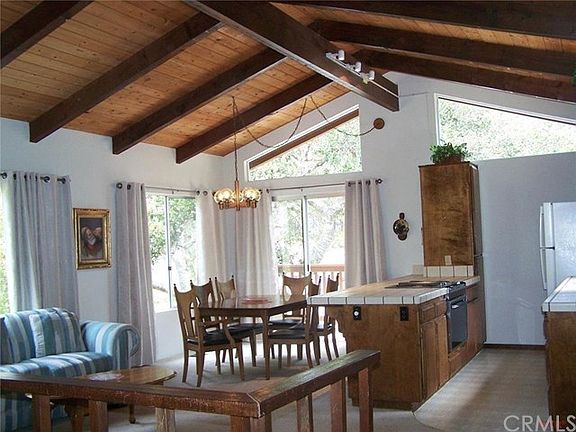 Open and vaulted kitchen, dining and living from top of stairs.