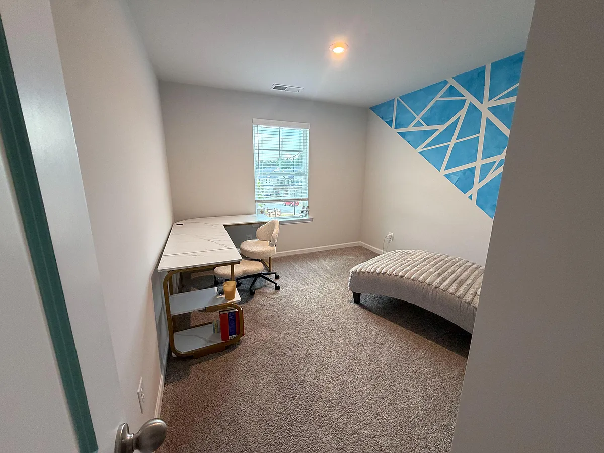 Private bedroom with a window, carpeted flooring, and space for a desk setup plus a chaise lounge for relaxing. - Park Center Cir