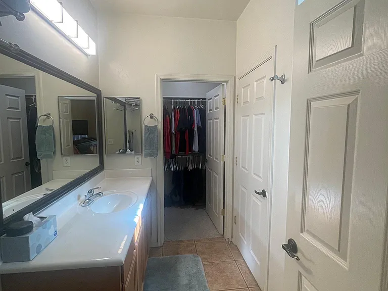 Entrance to master bathroom from master bedroom looking to the walk in closet. Toilet room on right and walk in shower
