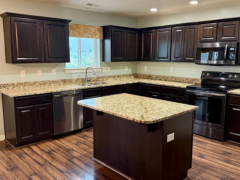 Large kitchen overlooking the backyard, Jordan River Parkway Trail and mountains.
