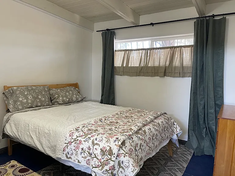 Second bedroom has Queen sized bed. Air conditioning/heating unit, black out curtains, dresser, and standard sized closet, tile floor with area rug.