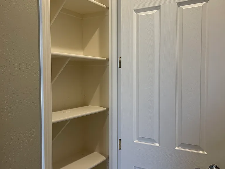 Linen closet/storage in hallway between two secondary bedrooms.