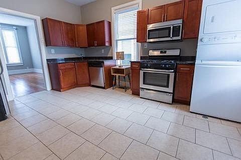 Cherry cabinets, granite counters, stainless appliances and your own in-unit washer and dryer!! Living room view to the left of this image.