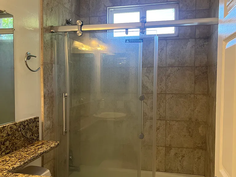 SECOND BATHROOM HAS DESIGNER TILE AND NEW SHOWER DOOR
