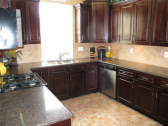 Super impressive kitchen features granite countertops, 42" cabinets, tile backsplash & floor, stainless steel appliances, & 2" blinds!