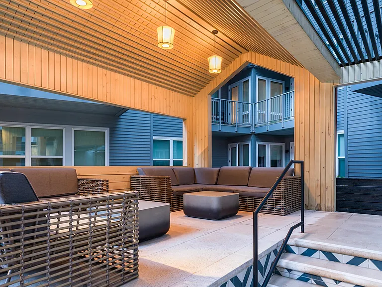 Relax under covered seating at Modera Old Ivy, where warm lighting and refined outdoor spaces offer a polished escape.