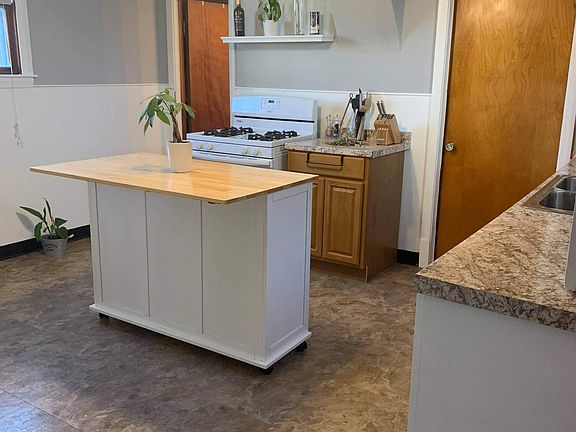 Kitchen has a large white refrigerator & white stove if you need to use..also has a dishwasher...1 door is to a newer bathroom other door is laundry room