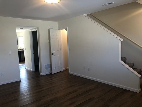 LIVING ROOM, STORAGE CLOSET UNDER STAIRS, PARTIALY SEE THE LAUNDRY ROOM AND KITCHEN , THE STAIRS LEAD TO THE LINEN CLOSET, THEN TWO BED ROOMS AND TWO FULL BATHROOMS UPSTAIRS
