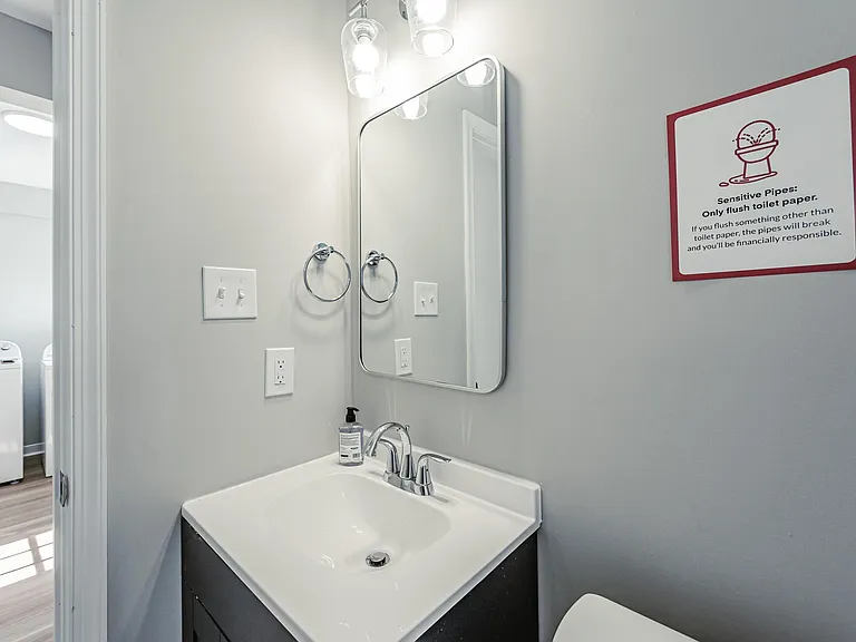 Bathroom vanity area with a clean sink, framed mirror, and overhead lighting for easy daily routines.