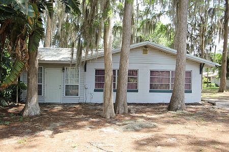Cute home nestled under beautiful tall cypress trees.