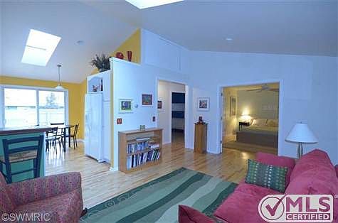 Open floorplan, vibrant accent walls, spacious living space with sky lights.