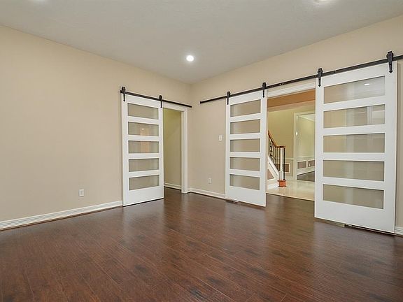 Gleaming wood floors and hanging doors in the study.