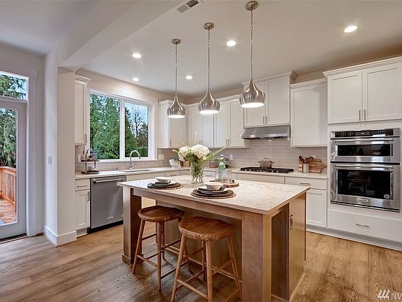Gourmet kitchen with breakfast bar, large walk-in pantry, pendant lights, quartz countertops, Kitchen-Aid appliances 5 -burner gas cooktop