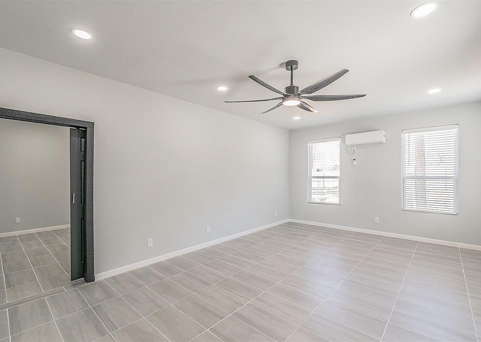 Spare room with baseboards, ceiling fan, recessed lighting, and an AC wall unit