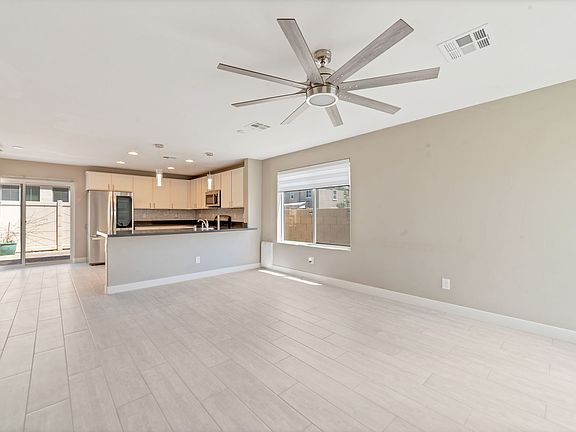Bright Living Spaces: Natural light floods in through custom window coverings, creating an inviting ambiance in the expansive living and dining areas.