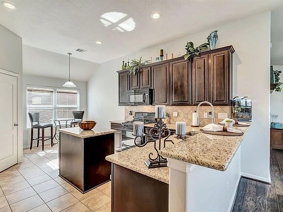 Island kitchen with 42 inch hardwood cabinets, granite counter tops and tile back splash