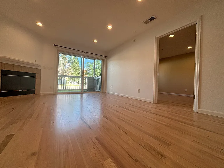 entrance - view of living space, fireplace, balcony, and main bedroom