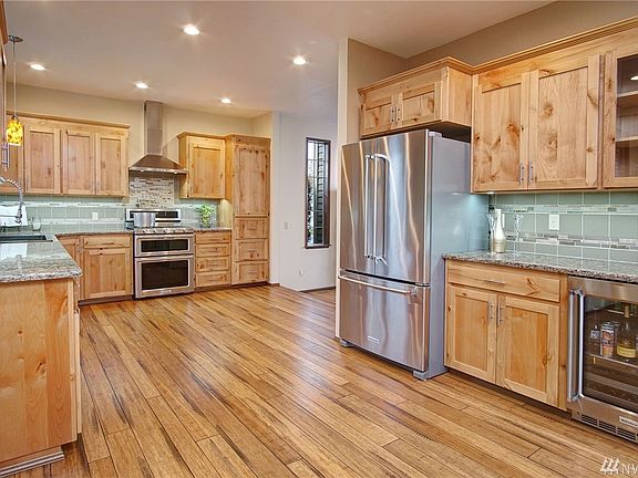 Kitchen features customs cabinets with soft close cabinets and drawers, full under-cabinet tile back splash, quartz counter tops and under-counter lighting. Dual temperature control beverage & wine fridge. And more!  Pot-filler faucet above gas range with electric ovens too!  Fantastic appliance package!
