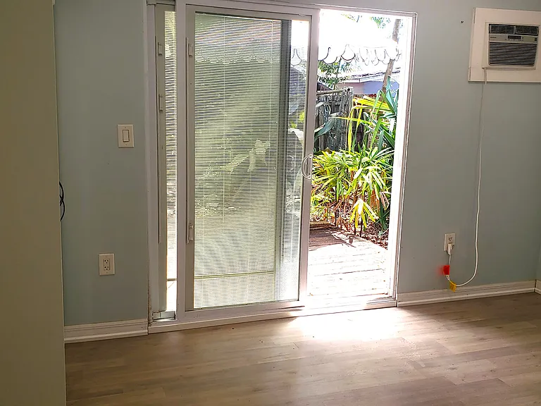 Large bedroom with sliding doors leading out to backyard