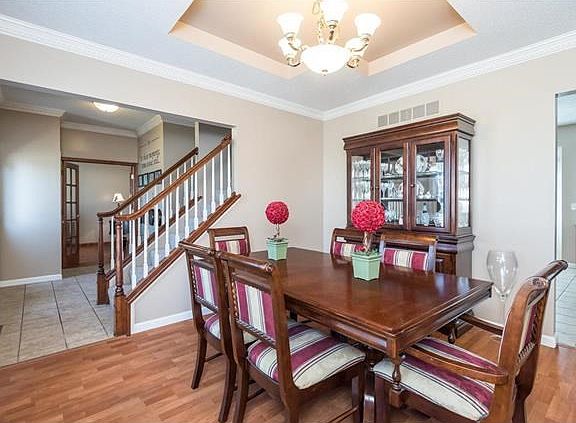 Lovely formal dining room has a tray ceiling and crown molding for a dramatic effect.