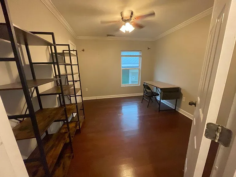 Bedroom 2 set up as a home office with desk, chairs, and shelving _ flexible as a guest room or workspace.