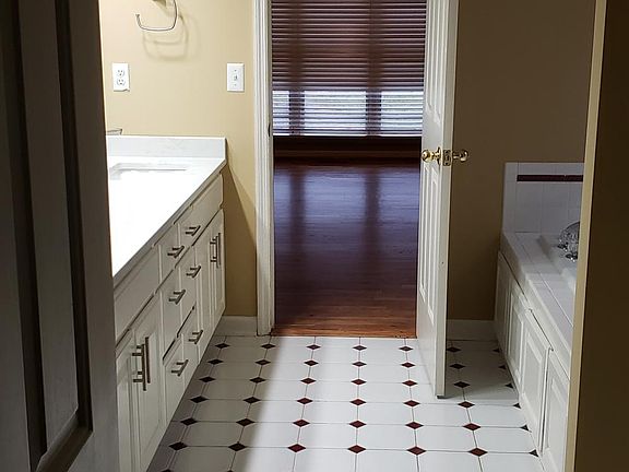 view from master bedroom closet through bathroom to bedroom, jetted tub, shower, toilet room