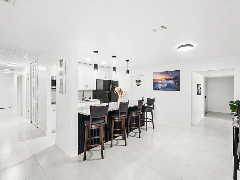 Open kitchen with breakfast bar seating, ample cabinetry, and full-size appliancesideal for daily meals and entertaining.