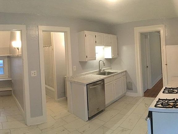 Full kitchen with dishwasher. First door on the left is the entrance from the back stairwell. 2nd door from the left is the bathroom. 3rd door from the left is doorway into the living room.