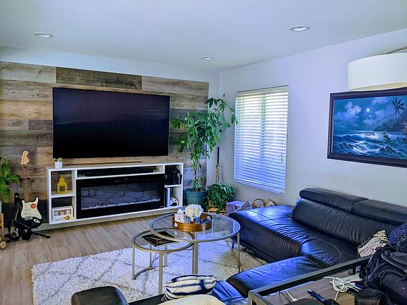 Wooden panel statement wall with mounting rack for TV, floating shelf for equipment. The Elecric fireplace in the center of the shelf can be removed for more storage.